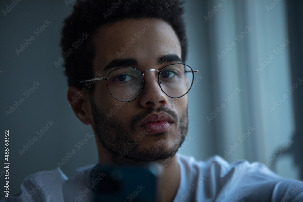 Obraz premium Portrait of an african american man in glasses using a smartphone.