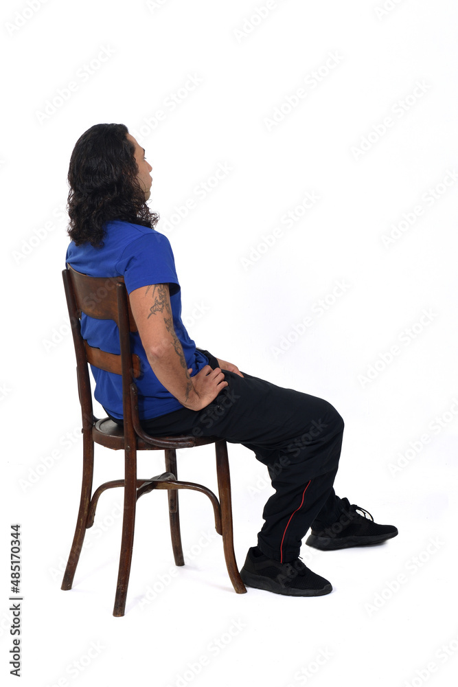 side and rear view of a man with sportswear sitting on chair on white background side and rear view of a man with sportswear sitting on chair on white background