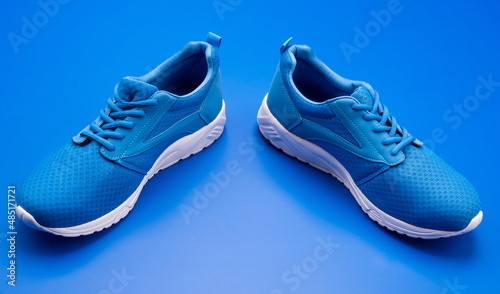 pair of footwear for training on blue background, shoes