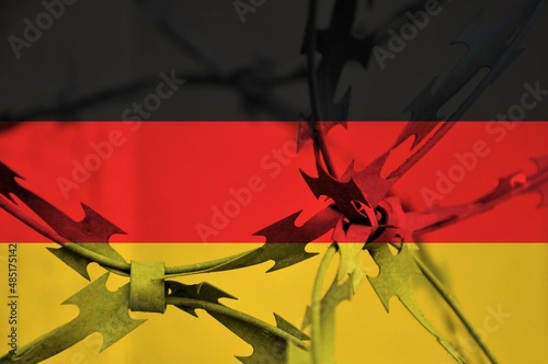 Abstract image of the national flag of Germany with twisted barbed wire.