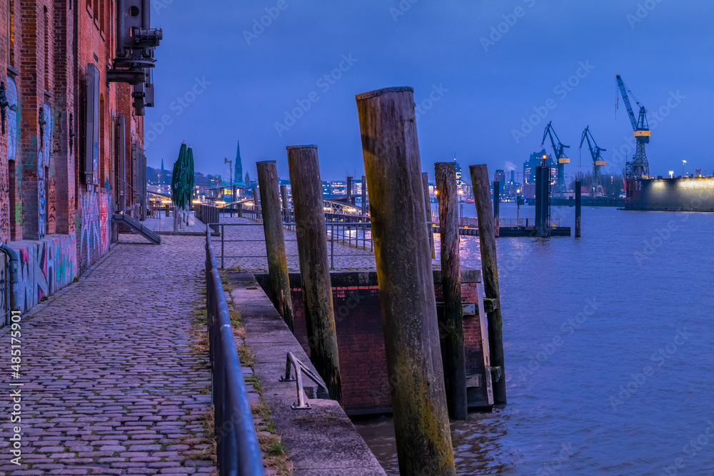 Hamburg, Germany. View of the harbor with historic pier and the river Elbe at night.