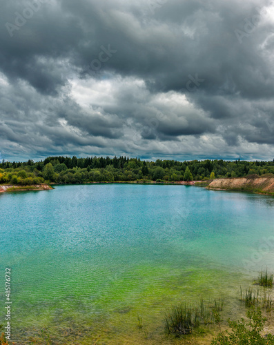lake near the forest on a cloudy gloomy summer day
