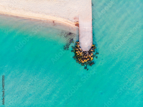 top view of the turquoise sea, sandy beach and pier