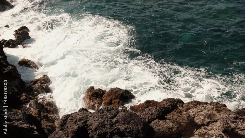 Picturesque large wave in ocean crashes against rocks splashes Picturesque large wave in ocean crashes against rocks splashes