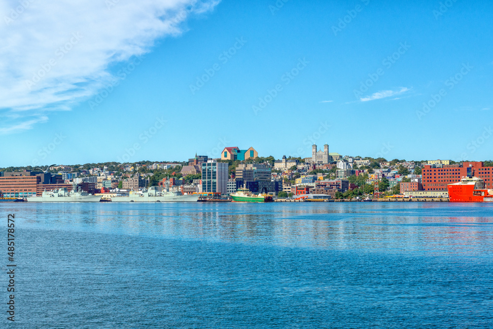 St. John's, Newfoundland, Canada - February 2022: Colorful downtown St. John's with historic wooden residential, commercial, business, and Federal Government buildings. There are colorful ships docked