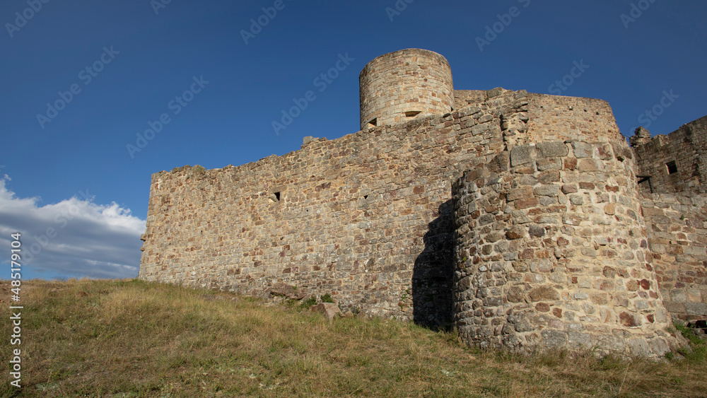 Fortification médiévale en ruine sur une colline des montagnes cévenoles sous le ciel bleu d'été en France.