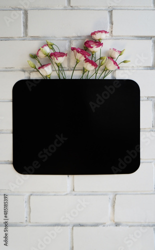 flowers and magnetic board on a brick wall