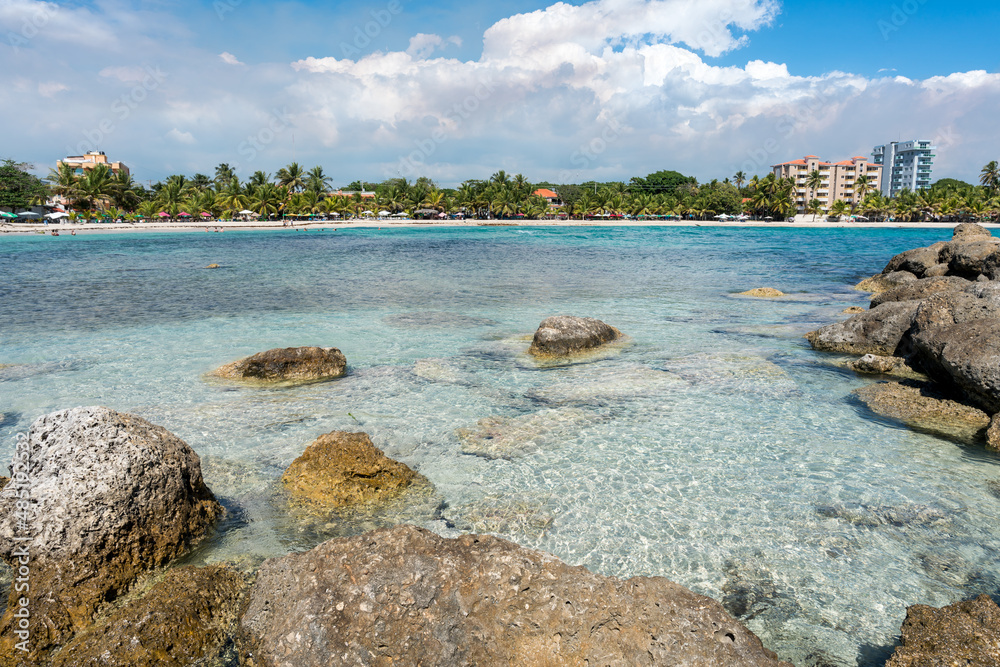 Dramatic image of the Caribbean coast of Juan Dolio, Dominican Republic with large rocks in the foreground and the white sandy beaches on the horizon. Dramatic image of the Caribbean coast of Juan Dolio, Dominican Republic with large rocks in the foreground and the white sandy beaches on the horizon.