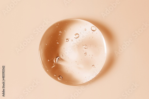Cosmetic serum gel beauty oil drop on color background. Skin care product droplet with bubbles texture macro