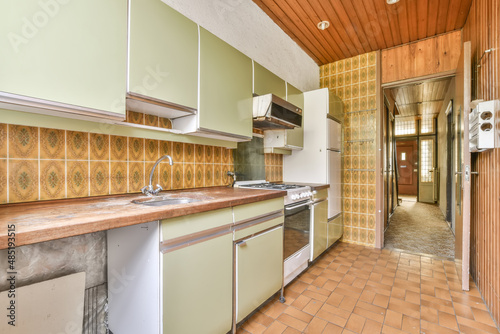 old fashioned kitchen with green cabinets and a white fridge