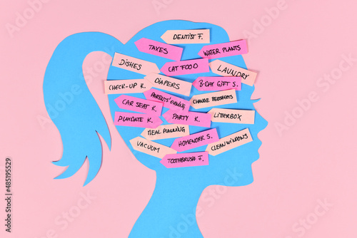 Mental load concept with woman's head silhouette with multiple tasks on notes photo