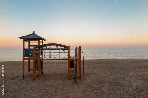beach scene at sunset with a playground in the foreground