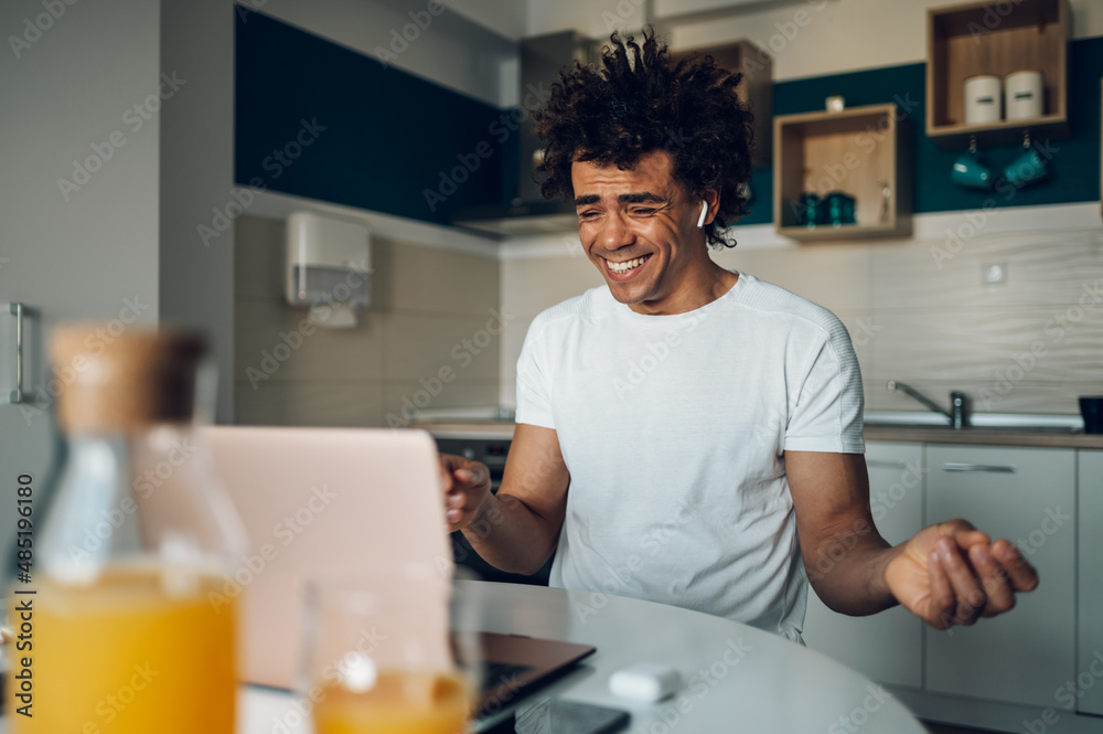 African american man using a laptop for a video call while working from home