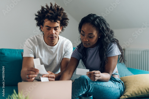 African american couple using a laptop and a credit card while doing finances