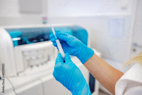 Close up of a nurse holding a syringe and preparing to take a blood sample from a patient.