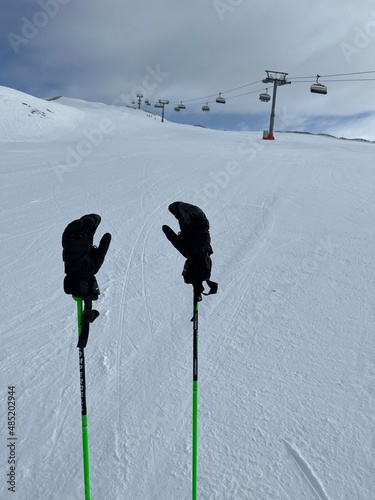 Hanschuhe auf den Skistöcken auf der Skipiste photo