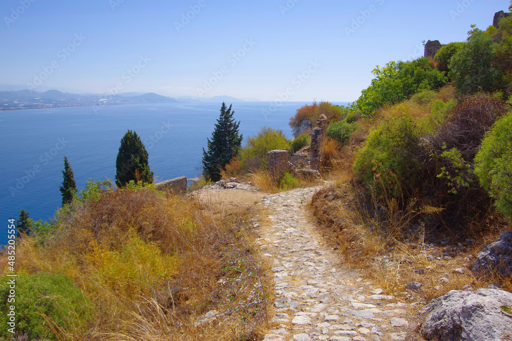 A stone-paved path high in the mountains above the sea.