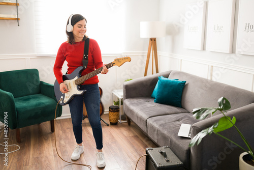 Excited female guitarist rehearsing