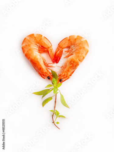 Heart shaped shrimp with lime and herbs on white background.