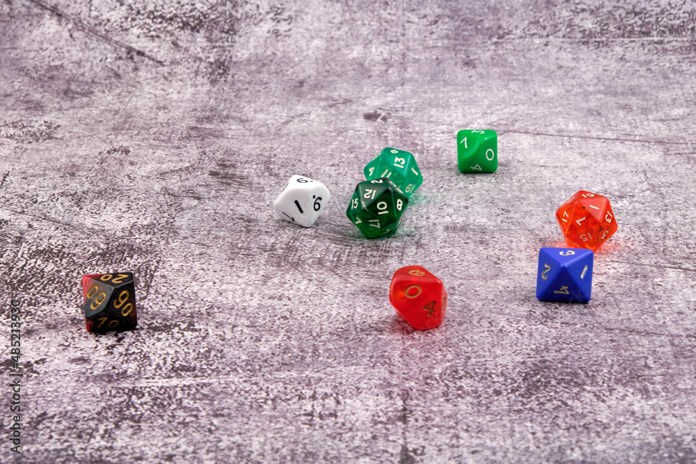 Different colored dice on an abstract cement-like background