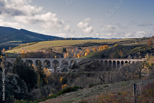 Viaduc de voix ferré permettant au train de tarversé la vallée et les paysages d'automne. Montagne des Cévennes en France.