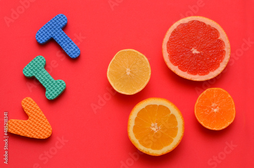 cutaway different types of citrus fruits and the letters vit on a red background