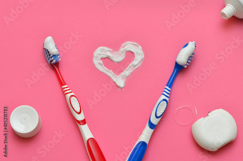 Fototapeta Naklejka Na Ścianę i Meble -  items for oral hygiene and toothpaste heart on a pink background