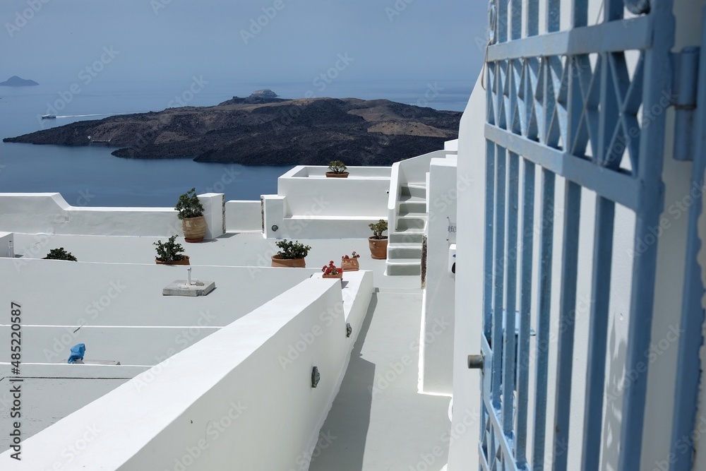 A door and steps leading to a residential building with a beautiful view on the Aegean Sea and the volcano of Santorini A door and steps leading to a residential building with a beautiful view on the Aegean Sea and the volcano of Santorini