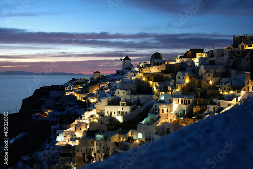 Amazing sunset at the picturesque and illuminated village of Oia in Santorini Greece