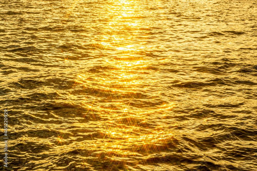 Glittering golden sea with sunlight reflecting off it
Glittering golden sea with sunlight reflecting off it