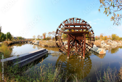 The wooden waterwheel is in the river