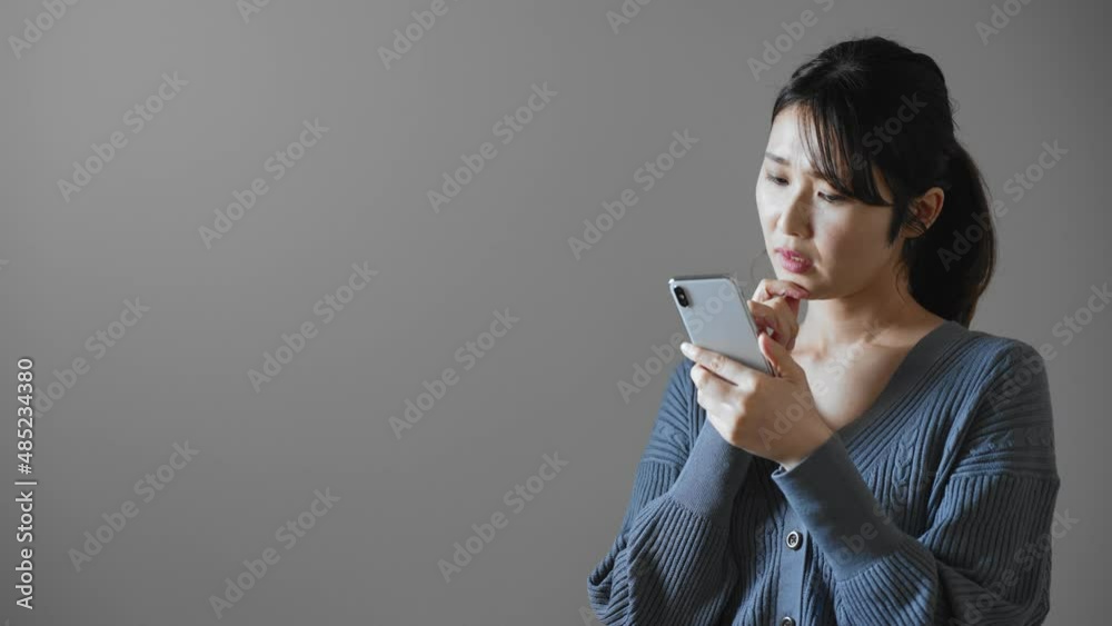 携帯電話を操作する若い女性 携帯電話を操作する若い女性