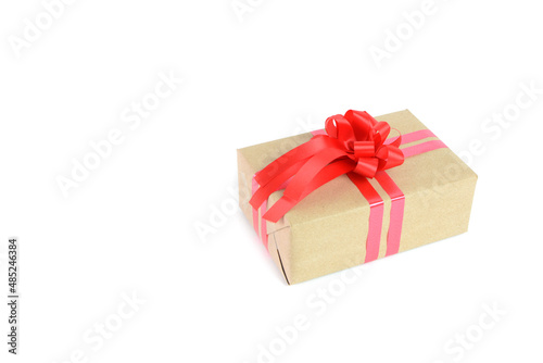 Brown craft gift box with red ribbon bow isolated on white background. © jpjengs
