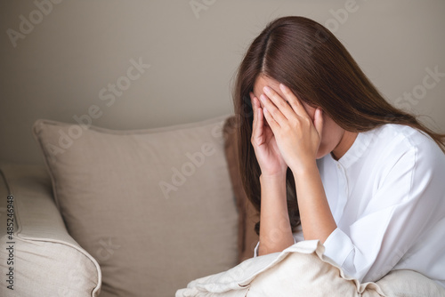 A young asian woman feeling sad and stressed, sick and headache at home