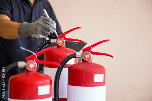 Fire extinguisher tank have engineer inspection checking pressure gauge level for protection and prevent and safety rescue and use of equipment on fire training concept.