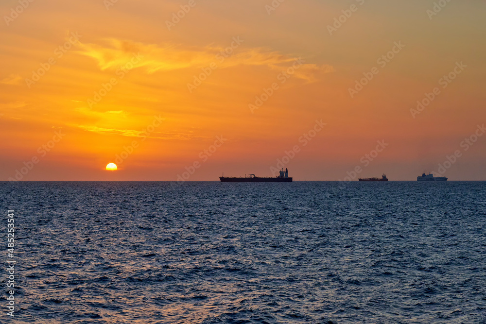 Sea view at sunset with ships moored in the roadstead. Italy, Liguria