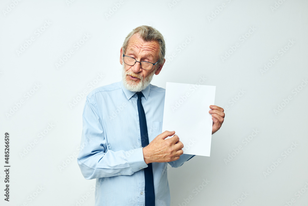 Portrait elderly man holding documents with a sheet of paper cropped view Portrait elderly man holding documents with a sheet of paper cropped view