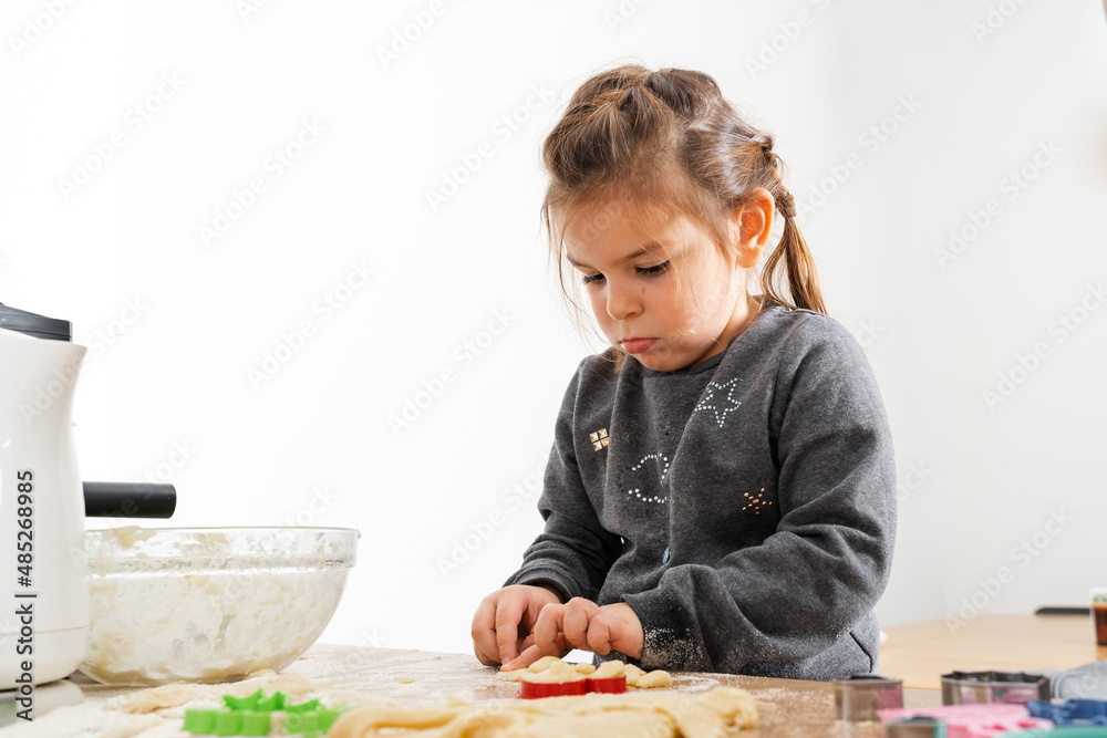 Funny little child girl cooking cookies with dough. Home activities for kids Funny little child girl cooking cookies with dough. Home activities for kids