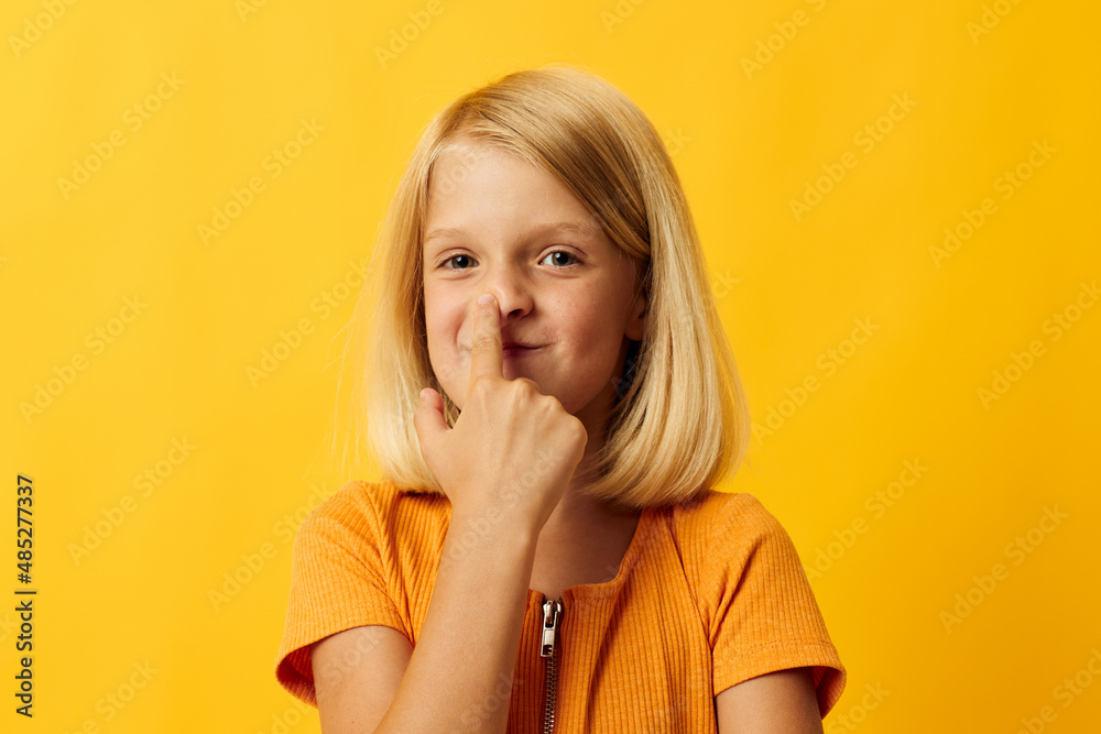 cheerful little girl hand gesture and fun yellow background
