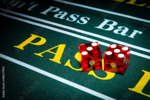 Professional casino-style dice sit on the pass section of a craps table. photo