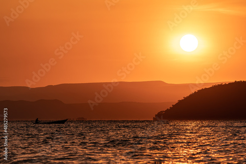 Beautiful orange sunrise over Lake Baringo with fisherman  Kenya 