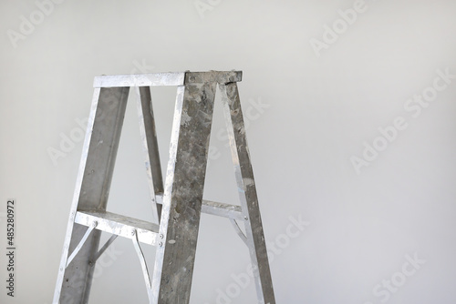 Close-up Aluminium ladder on white background for technician use to higher jobs. Image with copy space.