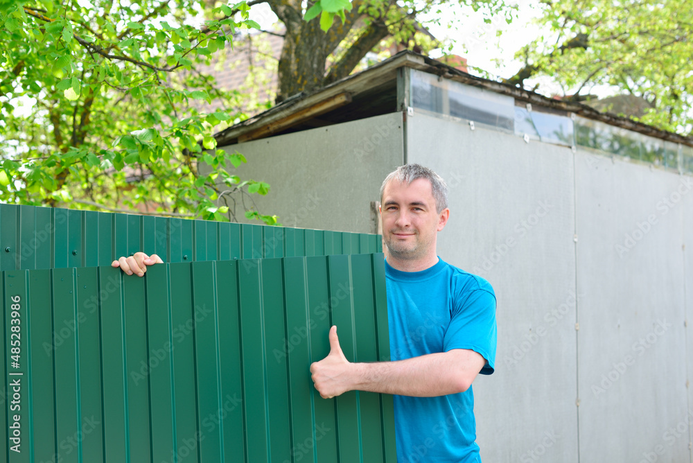 Man sets metal fence Man sets metal fence