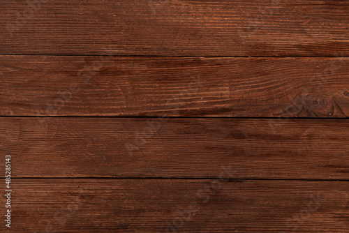 Vintage colored wood background texture with knots and nail holes. Old painted wood wall. Brown abstract background. Vintage wooden dark horizontal boards. Front view with copy space