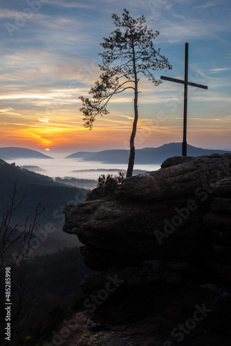 Four castles view, Rötzenfels, a sandstone rock with a cross and a tree. Sunrise in the fog, Palatinate Forest, Germany. landscape shot photo