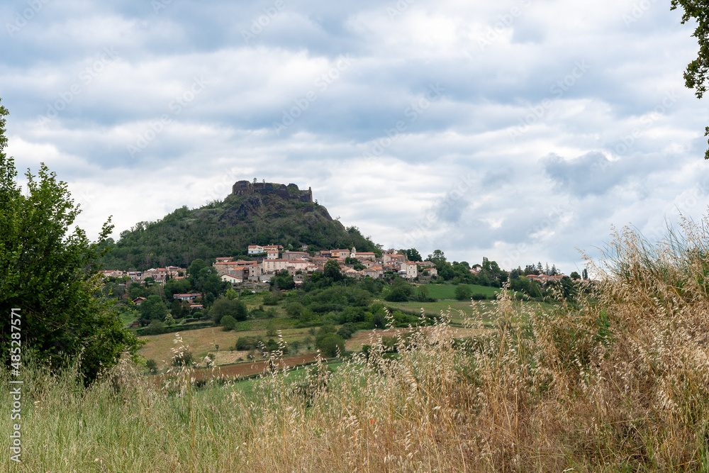 Village de Buron dans le Puy de dôme avec au sommet de la montagne la citadelle ancienne