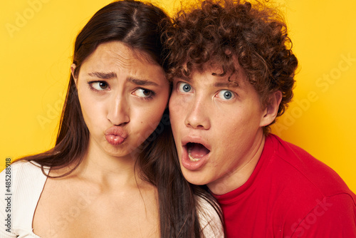 portrait of a man and a woman Friendship posing hugs together yellow background unaltered
