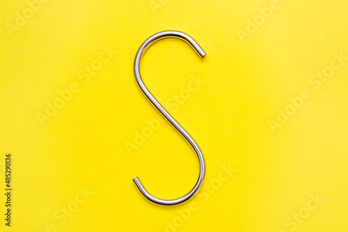 Foto Bright Stainless Steel S hook isolated on a yellow background