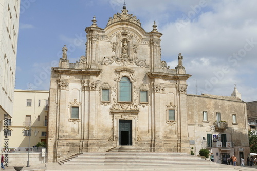Saint Francis church in Matera, the facade in baroque style made by white sandstone with the staircase in front of the entrance door and the decorations.