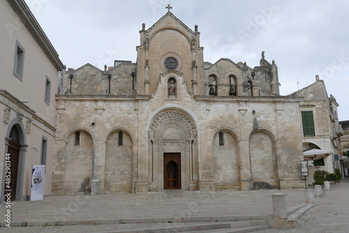 St. John Baptist church in Matera, the facade made by white sandstone with the decorated entrance door, the arches, the statues and the bells. © filippoph